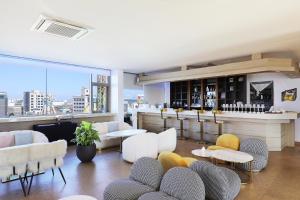 a room with a bar with white chairs and tables at Hotel The Sea Star in Incheon