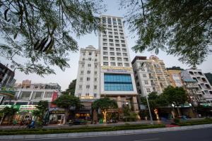 a tall white building in the middle of a city at Cat Ba Paradise Hotel - Travel Agency in Cat Ba