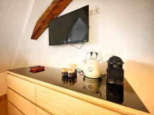 a counter top with a tv on a wall at Chambre Pastis in Eguisheim