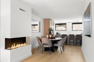 a dining room with a table and a fireplace at Fully serviced luxury townhouse near the Vigelandspark in Oslo