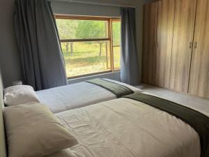 - une chambre avec un grand lit et une fenêtre dans l'établissement Bushveld Getaway, à Marloth Park