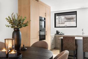 a kitchen with a table and a vase with a plant at Fully serviced luxury townhouse near the Vigelandspark in Oslo