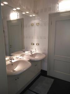 a white bathroom with two sinks and a mirror at Villa Lorenzo in Briosco