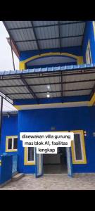 um edifício azul com um sinal na lateral em Villa Brastagi Gunung Mas em Berastagi
