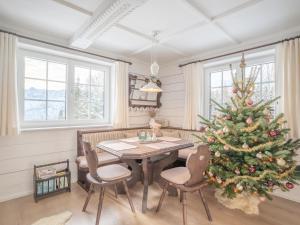 a dining room with a christmas tree and a table at Strickerl in Bad Goisern