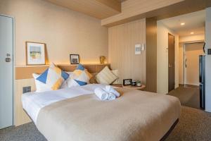 sypialnia z dużym łóżkiem z ręcznikami w obiekcie Apartment Hotel 11 Namba Minami w Osace