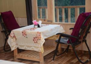 einen Tisch und zwei Stühle in einem Zimmer in der Unterkunft Mountain Bliss Cottages by StayApart in Shoja