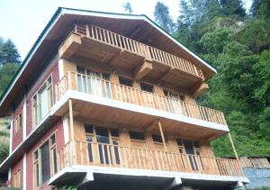 ein Gebäude mit Holzbalkonen darüber in der Unterkunft Mountain Bliss Cottages by StayApart in Shoja