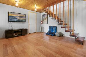 Habitación con escalera y sala de estar con suelo de madera. en FINNIAN'S CHALET - Close to Slopes and Lake, en Big Bear Lake