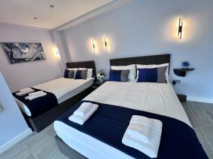 1 dormitorio con 2 camas y almohadas azules y blancas en Hyde Park Studio Flats en Londres