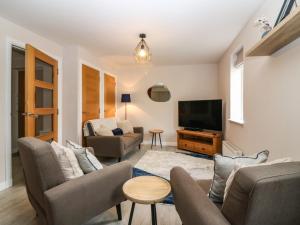 uma sala de estar com um sofá e uma televisão em 11 Ambleside Court em Banchory