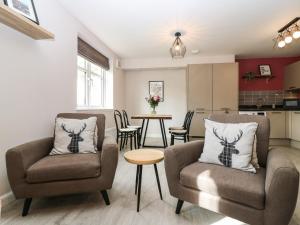 a living room with two chairs and a table at 11 Ambleside Court in Banchory