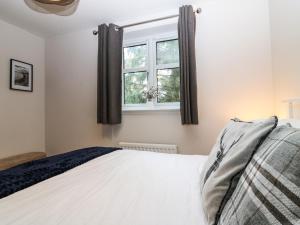 a bedroom with a bed and a window at 11 Ambleside Court in Banchory