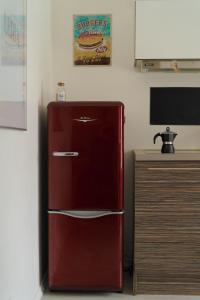 a red refrigerator in a room next to a desk at Modern DIY apartment in Petrikyula