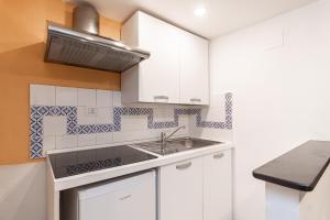 a kitchen with white cabinets and a sink at IMMOBIRENT - Centro città a 5 min Acquario in Genoa