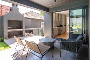 a patio with a table and chairs and a kitchen at Luxurious Family home in Newlands with Pool in Cape Town