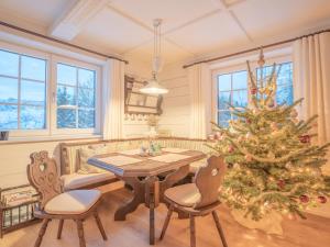 a christmas tree in a living room with a table and chairs at Strickerl in Bad Goisern