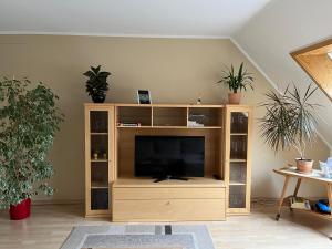 un centro de entretenimiento de madera con TV en la sala de estar en Ferienwohnung am Selenter See, en Selent