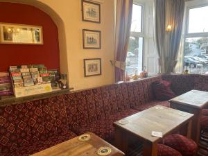 a bar with a couch and tables in a restaurant at The Board Inn in Hawes
