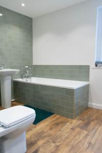 a bathroom with a tub and a toilet and a sink at Bridge House in Chichester