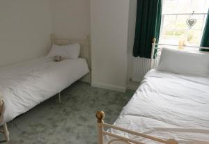 a small bedroom with two beds and a window at Bridge House in Chichester