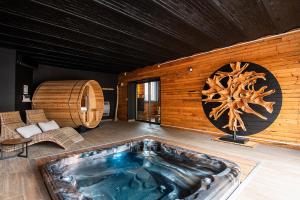 uma banheira de hidromassagem num quarto com uma parede de madeira em L'Odyssée Inattendue 