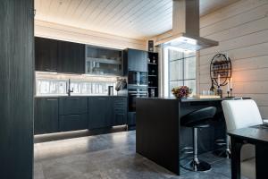 a kitchen with black cabinets and a black island at Lymyilevi in Levi