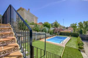 un patio trasero con piscina y escaleras en Chalet con Piscina en Aranjuez, en Aranjuez