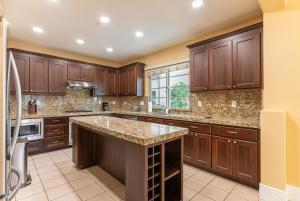 a kitchen with wooden cabinets and a large island at Milpitas 4br w garage nr mall dining SFO-1593 in Milpitas