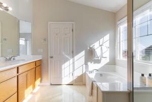 ein Badezimmer mit zwei Waschbecken, einer Badewanne und einem Fenster in der Unterkunft Newark 4br w backyard patio ac garage SFO-1586 in Newark + 39 Fotos