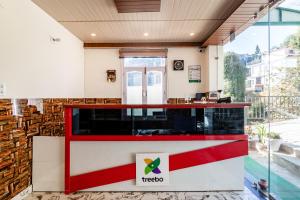 a restaurant with a red and white counter in a building at Treebo Trend Srishti Vaikunth in Shimla