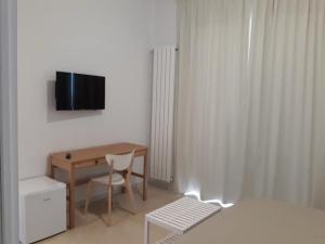 um quarto com uma mesa, uma cadeira e uma televisão em B&B LADY LUCIA em Porto Cesareo