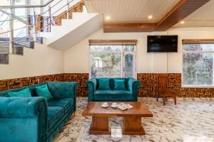 - un salon avec deux canapés verts et une table dans l'établissement Treebo Trend Srishti Vaikunth With Mountain View, à Shimla