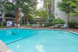 a large blue swimming pool with chairs and tables at Mountain View 1br w balcony pool nr shops SFO-1588 in Mountain View