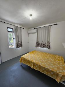 a bedroom with a yellow bed in a room at Cocotiers in Beau Champ