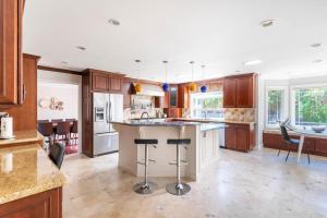 a kitchen with wooden cabinets and a island with bar stools at Los Gatos 5br w backyard nr trails wineries SFO-1614 in Los Gatos