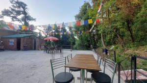 a patio with a wooden table and chairs and flags at HILL PARADIZÈ couple friendly in Mussoorie