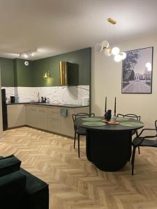 a living room with a table and a kitchen at Apartament Twój ZDRÓJ & SPA Dr Duda in Busko-Zdrój