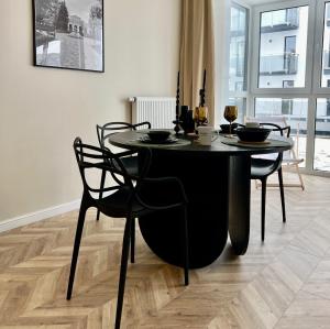 uma mesa preta e cadeiras num quarto em Apartament Twój ZDRÓJ & SPA Dr Duda em Busko-Zdrój