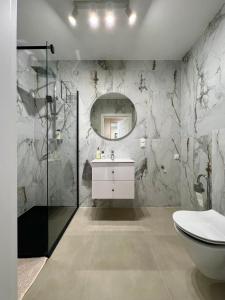 W łazience znajduje się toaleta, umywalka i lustro. w obiekcie Apartament Twój ZDRÓJ & SPA Dr Duda w Busku Zdroju