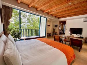 1 dormitorio con cama grande y ventana grande en 慎重開華莊園民宿, en Puli