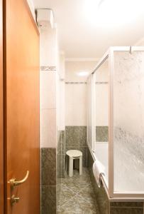 a bathroom with a shower with a toilet and a stool at Hotel Cavour in Rapallo