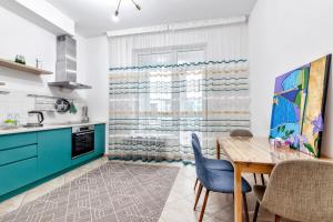 a kitchen with a wooden table and blue cabinets at Комфортная квартира на ЭКСПО/ Comfortable flat on EXPO in Taldykolʼ