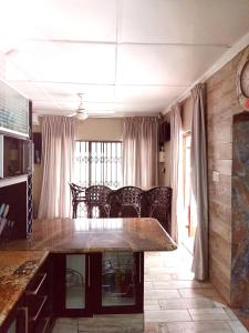 a kitchen with a table and chairs in a room at Peace Cottages Uvongo. in Uvongo Beach