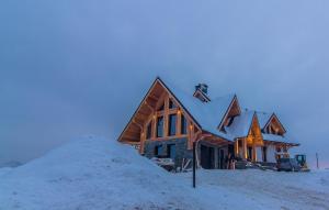 a house with a pile of snow in front of it at Rozmus Apartamenty in Bukowina Tatrzańska