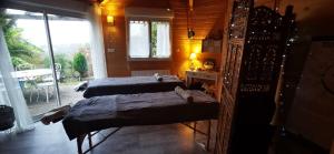 two beds in a room with a window at Chalet-studio Bien-Hetre in Fichous-Riumayou