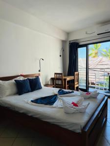 a bedroom with a large bed with a view of the ocean at Hôtel Grand Bay in Nosy Be