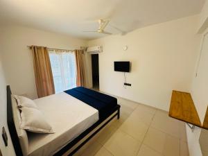 een slaapkamer met een bed en een tv. bij Tanour stay in Bangalore