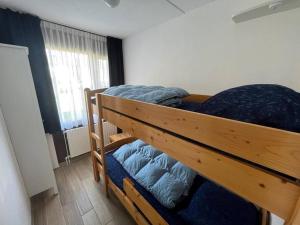 a bedroom with two bunk beds and a window at Schorrebloem 34* in Nieuwvliet