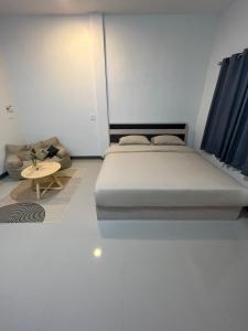 ein Schlafzimmer mit einem großen Bett und einem Tisch in der Unterkunft พรสินี 